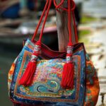 brightly-colored-handbag-with-red-tassels-wooden-post-generative-ai_1034973-94476